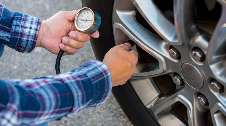 Person checking tire pressure