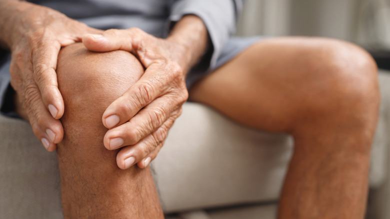 Seated man clasping knee