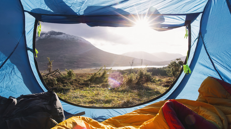 View of a mountain and river through an open tent door