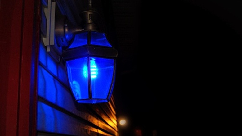 A blue light shines on the front of a home