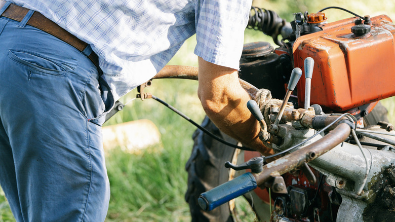 A man working on his lawn mower's internals