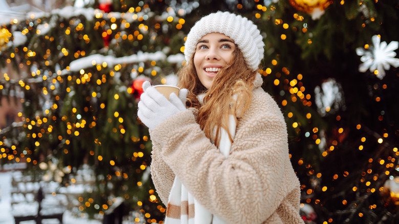 Woman dressed for cold weather drinking cocoa