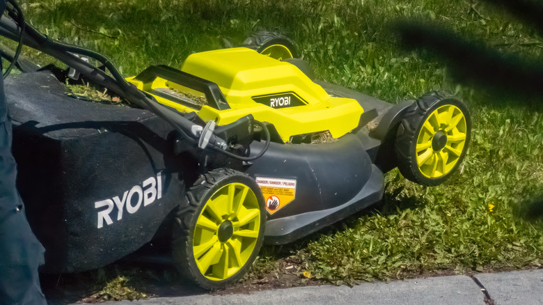 A close up of a RYOBI 20-inch 13 Amp Electric Walk Behind Lawn Mower.