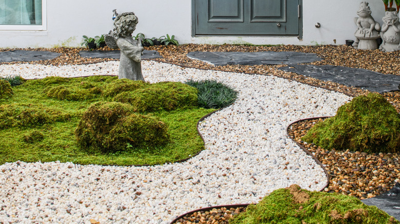 A garden path made of white gravel, leading up to a house