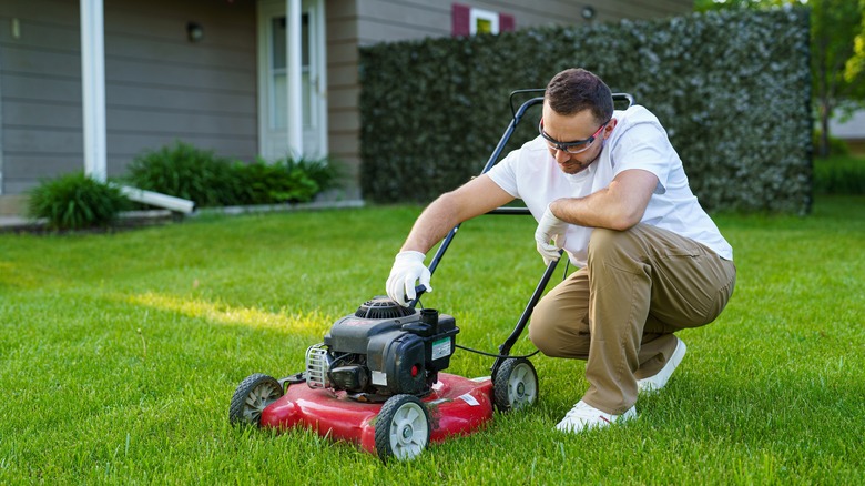 Man checking lawn mower's oil