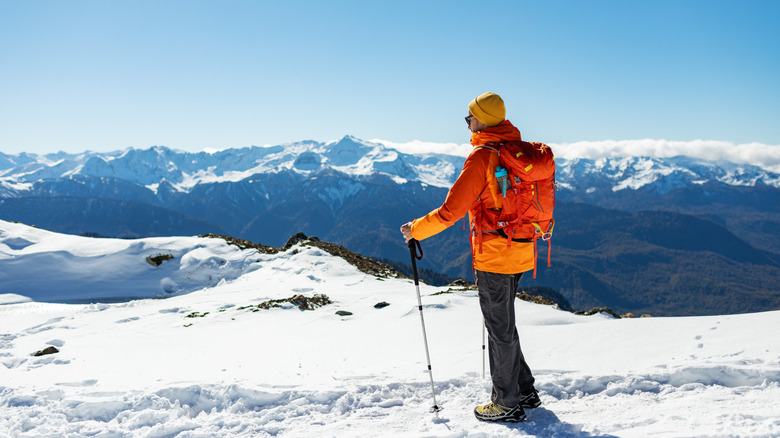 solo hiker in snow covered mountains