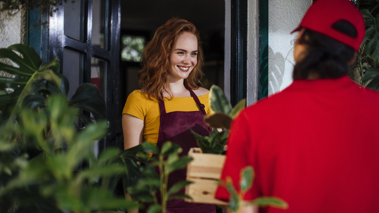 Woman receiving delivery order of plants to front door