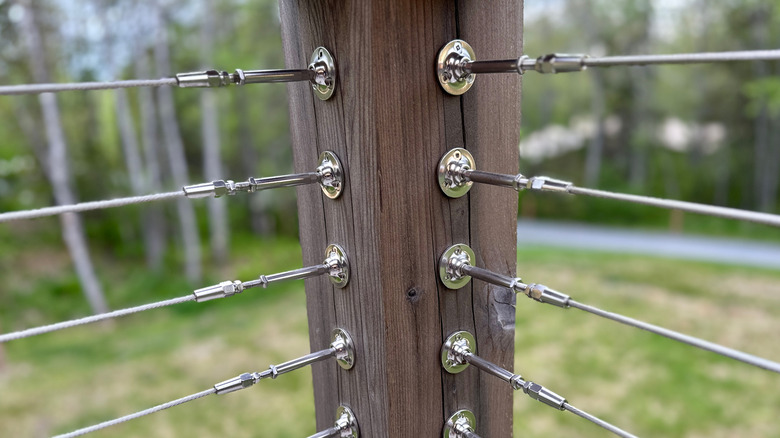 Close-up view of railing cables attached on a post closely together