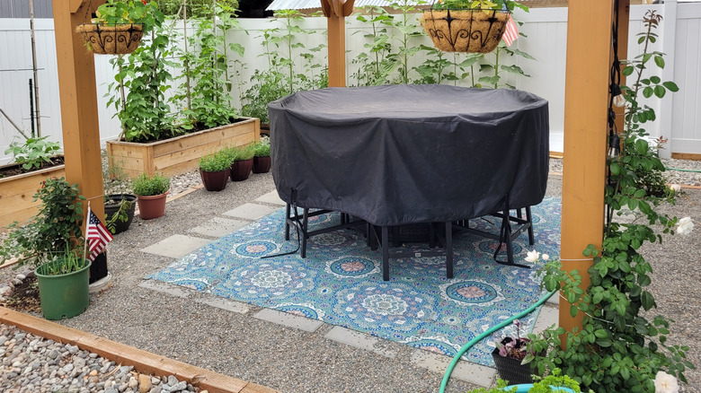 pea gravel patio with a covered patio table and chairs