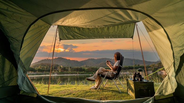 View of person enjoying natural scenery through tent