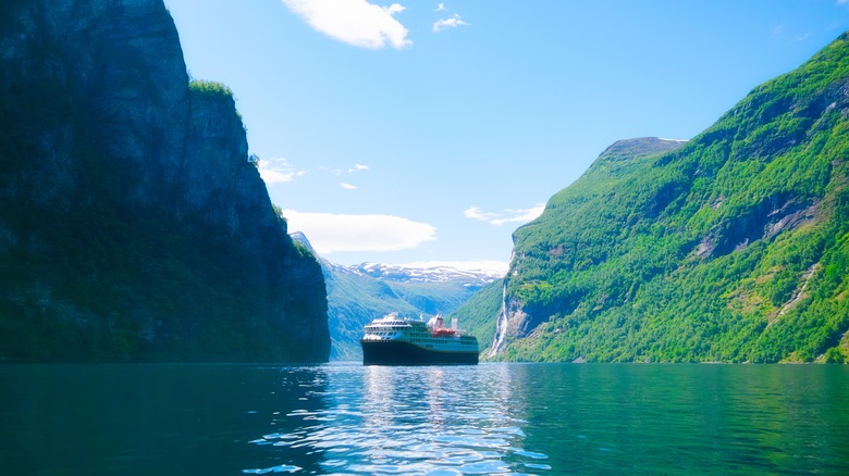cruise ship sails through a fjord in Norway
