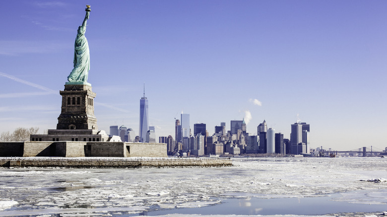 Sheets of ice on water in front of Statue of Liberty