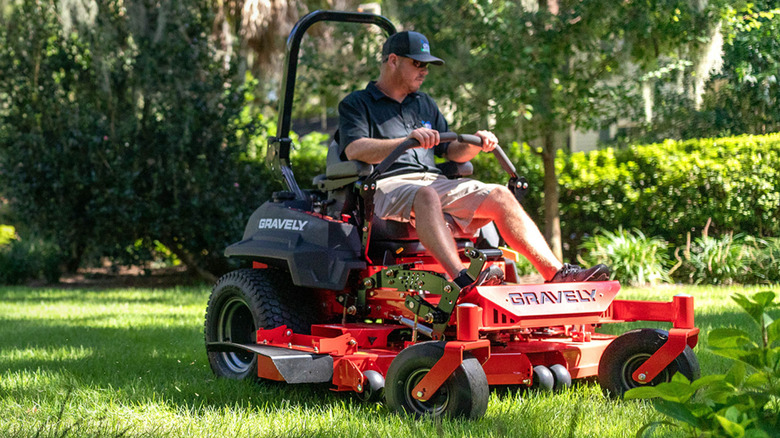 Someone mowing their yard with a riding Gravely lawn mowersn m