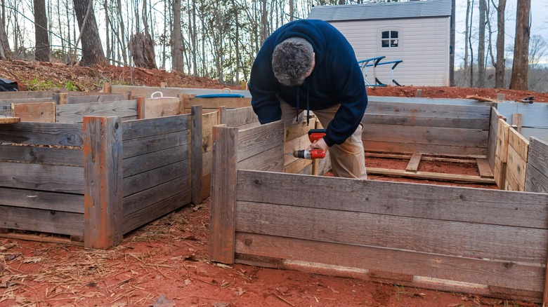Man building raised garden bed in cold weather