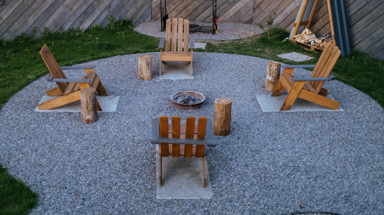 A gravel patio with rustic seating