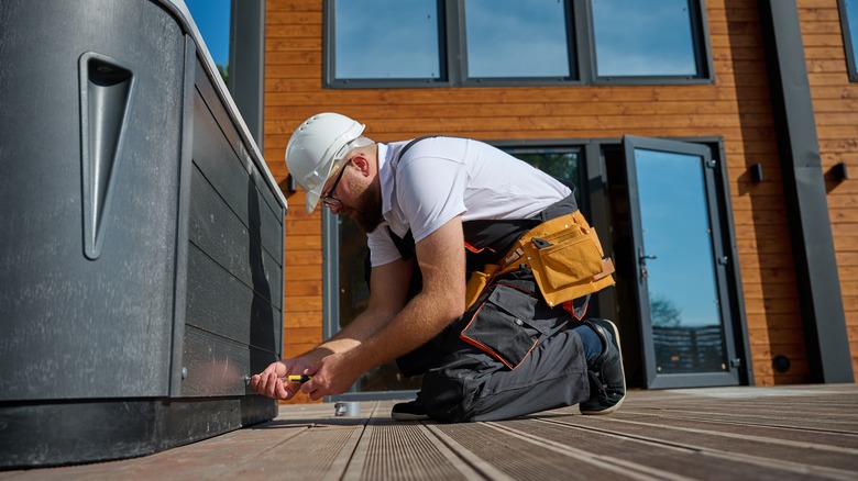 Worker installing hot tub on wood deck