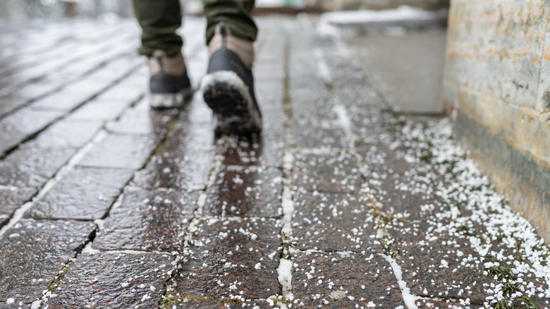 An icy walkway is coated with road salt