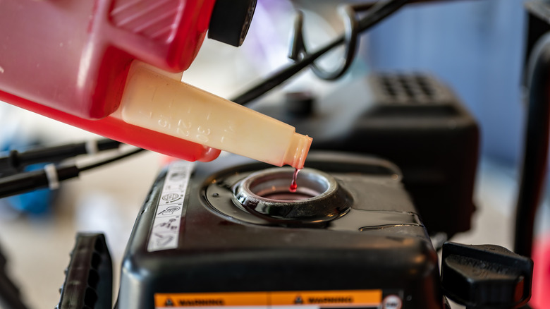 pouring fuel stabilizer into lawn mower gas tank