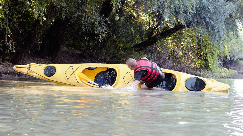 Man bailing out of kayak as it flips