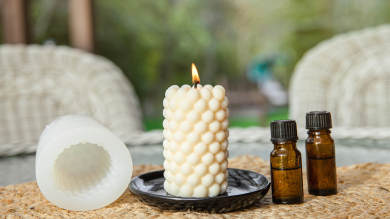 Homemade candle and essential oils on a patio