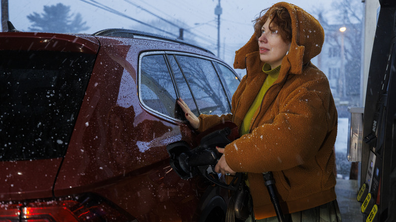 Person filling up with gas as snowstorm starts