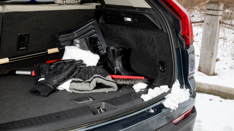 Back of a car filled with emergency snow gear and shovel