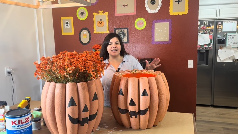 A DIYer poses with her homemade pumpkin planters