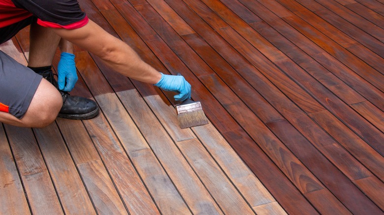 Man staining wood deck